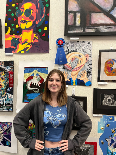 A Student in front of multiple art pieces.